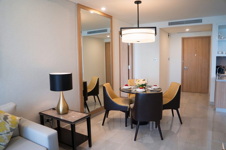Dining area of comfortable studio flat or hotel room. Set dining table prepared for dinner with Asian cuisine. City apartment and interior concept